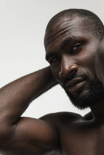 Close-up jovem bonito homem africano musculado isolado sobre fundo branco. Conceito de beleza, cosméticos, spa. - Foto, Imagem