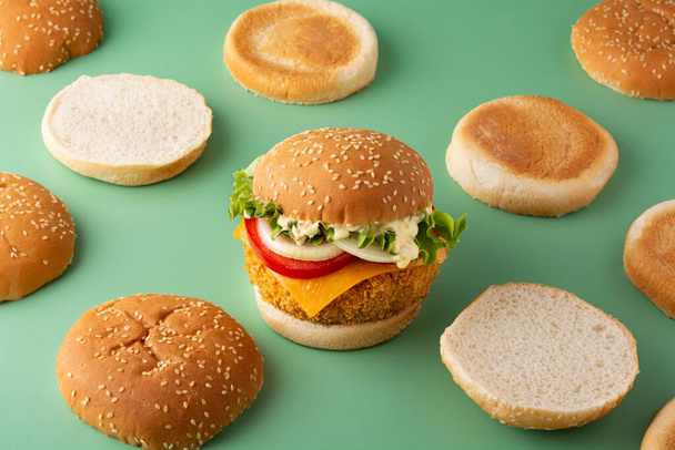 Crispy kip hamburger op groene achtergrond - Foto, afbeelding