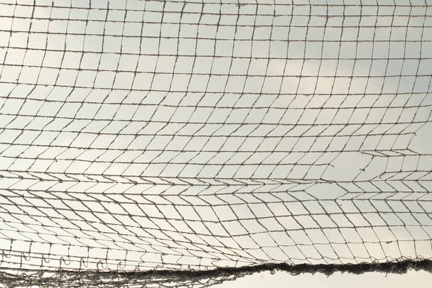 Сетка в клетке в снегу против голубого неба. - Фото, изображение