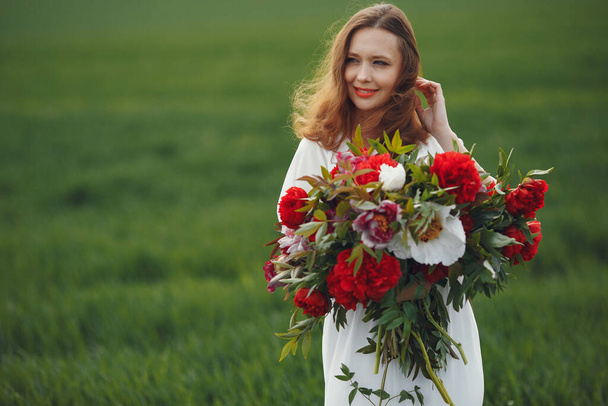 Woman in elegant dress standing in a summer field - Fotó, kép