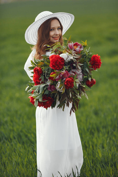 Woman in elegant dress standing in a summer field - Zdjęcie, obraz