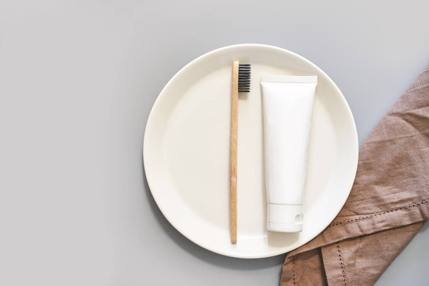 Ecology toothbrush on grey background. Brush on plate. Breakfast concept - Foto, afbeelding