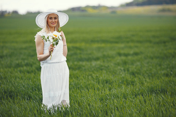 Woman in elegant dress standing in a summer field - Fotoğraf, Görsel