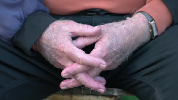 Közelkép az öregemberről, aki fogja egymás kezét.. - Felvétel, videó