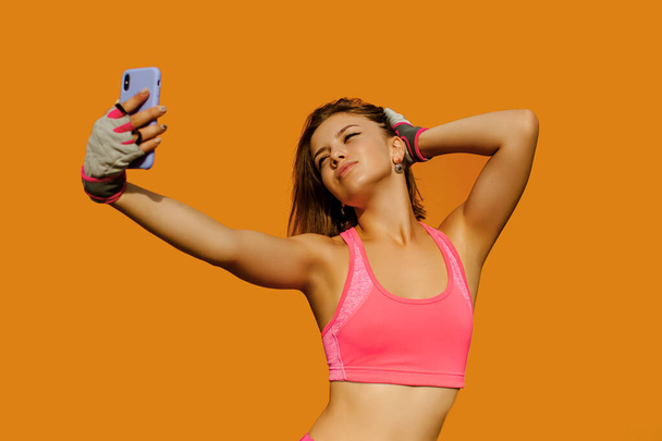 Jonge mooie fitness vrouw in sport outfit, het nemen van selfie - Foto, afbeelding