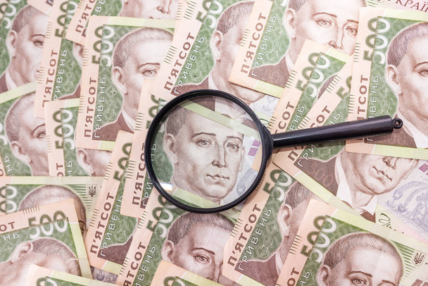 magnifier on a background with hryvnia. Ukrainian money. 500 hryvnia. Check money with a magnifying glass. - Photo, image