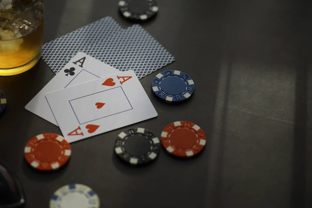 Glücksspiel-Kartenspiele für Geld. Texas Hold'em Poker. Karten in der Hand, Spielchips, Kartenstapel mit Alkohol im Glas. - Foto, Bild