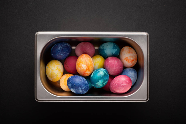 Пасхальные яйца в металлическом контейнере закрываются на черном фоне - Фото, изображение