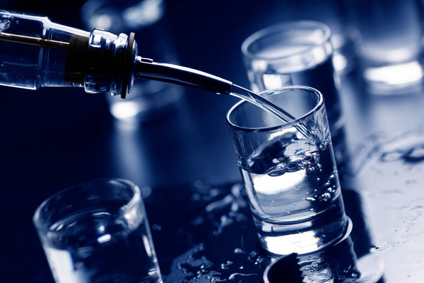 Русская водка наливается из бутылки в стекло в баре.. - Фото, изображение