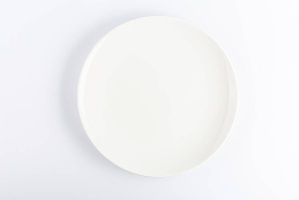 Empty ceramic round plate isolated on white background - Photo, Image