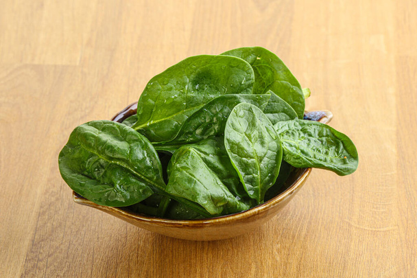 Fresh green spinach leaves in the bowl over wooden background - Photo, Image