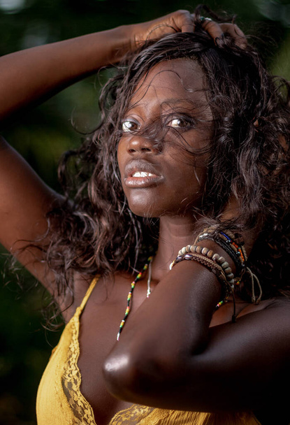 A vertical portrait of an attractive African female in a yellow dress - Φωτογραφία, εικόνα