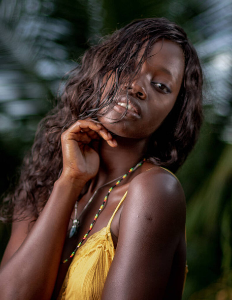 A vertical portrait of an attractive African female in a yellow dress - Foto, Bild