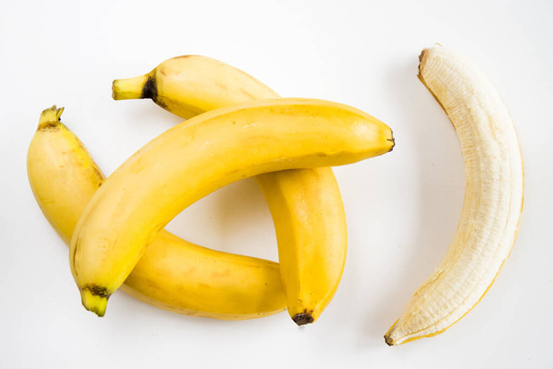 Fresh peeled and whole bananas isolated on a white background - Photo, Image