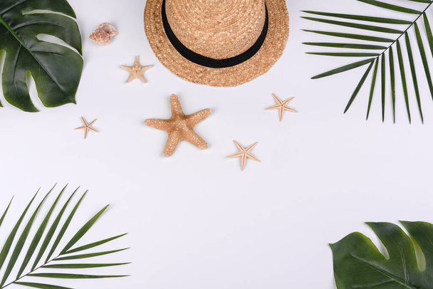 пляжные аксессуары: очки и шляпа с раковинами и морскими звездами на белом фоне. летний фон - Фото, изображение