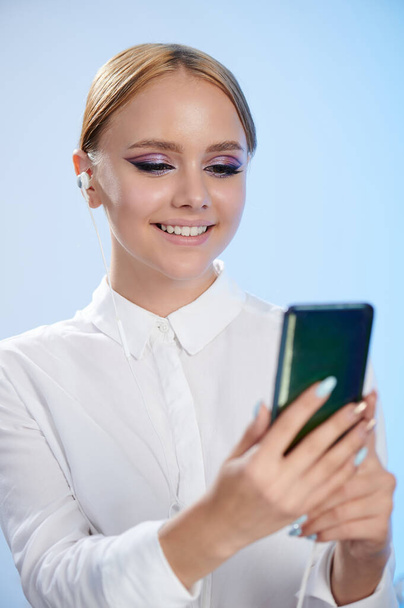 Young woman on video call portrait isolated on blue studio background - Φωτογραφία, εικόνα