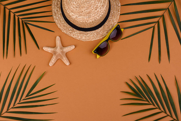 Beach accessories: glasses and hat with shells and sea stars on a colored background. Summer background - Photo, Image