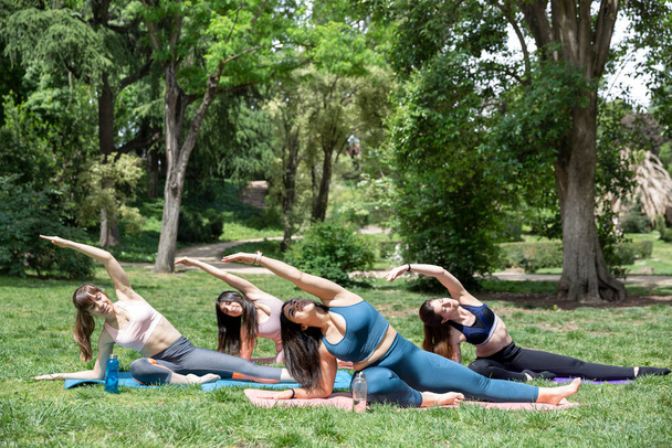 Grupo de mujeres jóvenes en clase de yoga al aire libre. Espacio para texto. - Foto, Imagen