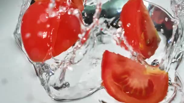 A piros paradicsomot lassan mossák nagy mennyiségű vízzel. - Felvétel, videó