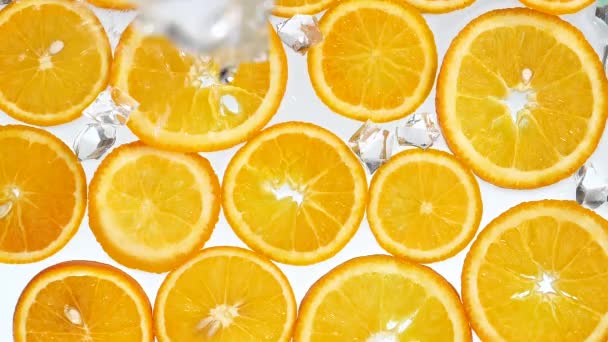 Оранжевые ломтики промывают ледяной водой - Кадры, видео