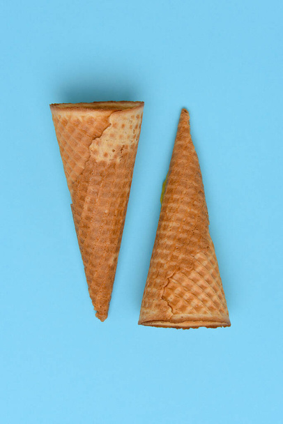 Two Ice Cream Cones on a blue background. Flat lay minimalist styling.  - Fotoğraf, Görsel