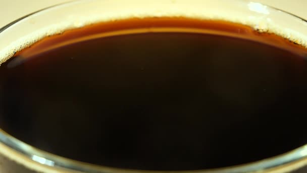 Una goccia cade lentamente nel caffè in una tazza - Filmati, video
