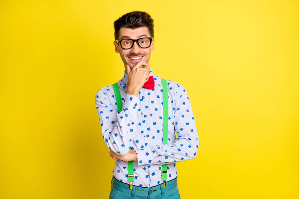 Photo of young cheerful brown hair man happy positive smile confident hand touch chin think isolated over yellow color background - Φωτογραφία, εικόνα