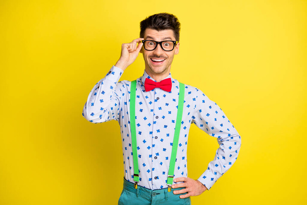 Photo of young excited man happy positive smile confident cool hand touch glasses isolated over yellow color background - Foto, Imagem