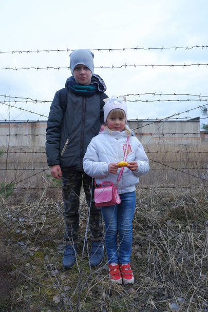 Kinder vor dem Hintergrund von Stacheldraht. Mangel an Freiheit, Hunger, Armut ... - Foto, Bild