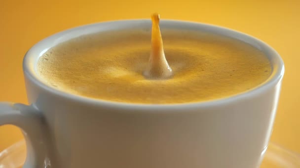 Une goutte tombe lentement dans le café dans une tasse - Séquence, vidéo