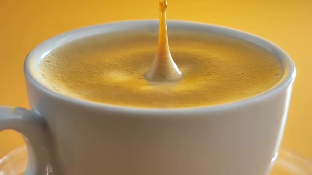 Una gota cae lentamente en el café en una taza - Imágenes, Vídeo