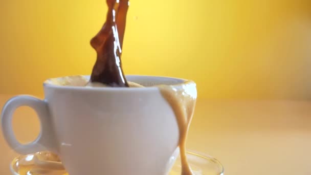 Ένα κομμάτι ζάχαρη πέφτει αργά σε ένα φλιτζάνι καφέ με πιτσιλιές. - Πλάνα, βίντεο