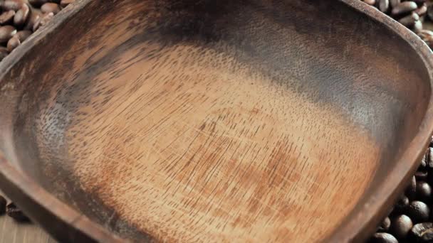 Chicchi di caffè tostati cadendo lentamente in un piatto - Filmati, video