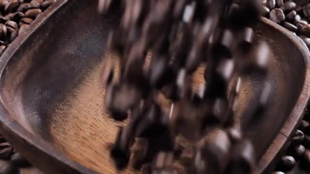 Chicchi di caffè tostati cadendo lentamente in un piatto - Filmati, video