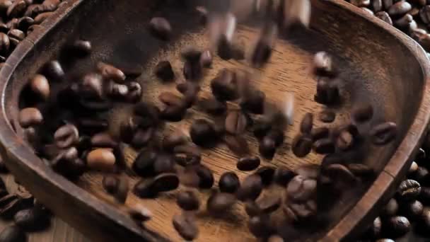 Granos de café tostados cayendo lentamente en un plato - Imágenes, Vídeo