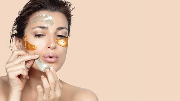 Close-up portrait of attractive girl applying different beauty patches on her face for fix every skin concern. Concept of natural beauty and skincare treatment cosmetic - 写真・画像