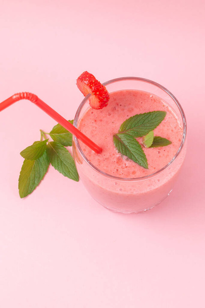 Jahodový mléčný koktejl s mátou na růžovém pozadí. Zdravé stravování na snídani a občerstvení - Fotografie, Obrázek