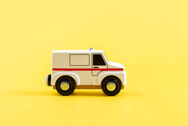 Childrens toy, car on a yellow background. Ambulance. Concept. Isolate. Copy space. - Photo, image