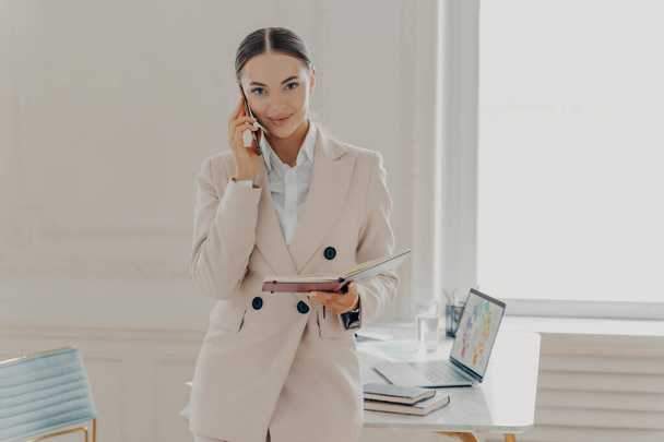 Young business lady talking on phone and discussing business ideas - Foto, imagen