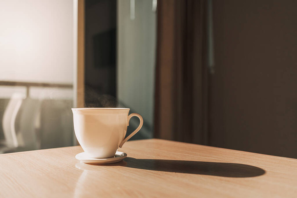 Hot cup of drink on the table in sun light of calm morning. - Foto, Bild