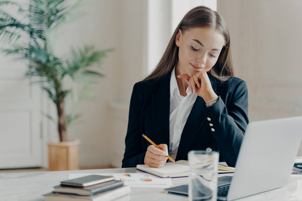 Концентрированная деловая женщина думает о проблемах работы в офисе - Фото, изображение