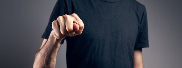 man showing offensive gesture on gray background - Photo, Image