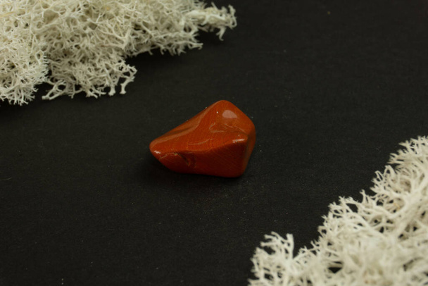 Red Jasper Brazíliából. Természetes ásványi kő fekete háttérrel. Ásványtan, geológia, kövek mágiája, féldrágakövek és ásványminták. Közelkép makró fotó - Fotó, kép