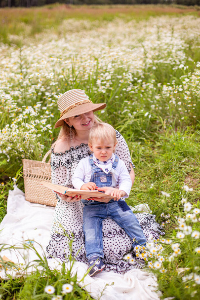 Junge Mutter und ihr süßer kleiner Sohn auf einem Feld - Foto, Bild