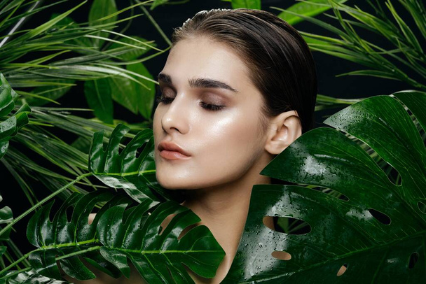 woman with clean skin near green palm leaves natural appearance - Photo, Image