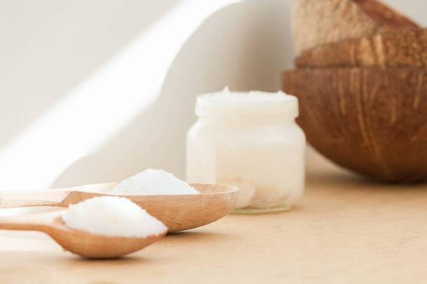 Coconut oil in jar and wooden spoon. Nature body, face, hair care concept. - Foto, Imagem