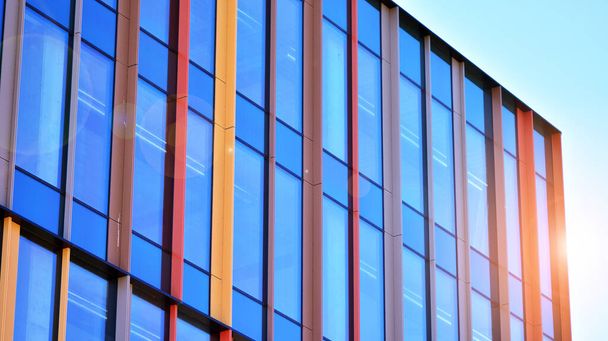 Reflexion eines modernen Geschäftshauses auf Glas mit Sonnenlicht. Geometrische Struktur Glasfenster.  - Foto, Bild
