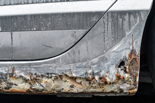 Corrosão pesada ou ferrugem aparecendo nos lados e no fundo do carro.  - Foto, Imagem