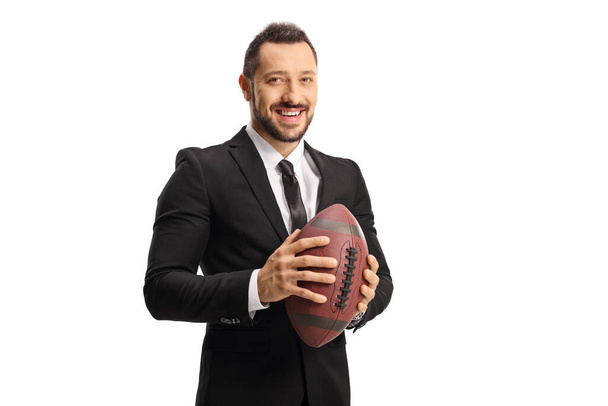 Young man in a suit and tie holding a rugby ball isolated on white background - Foto, Imagen