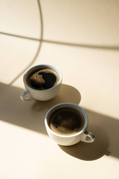 Two cups of coffee on beige studio background - Foto, Imagem